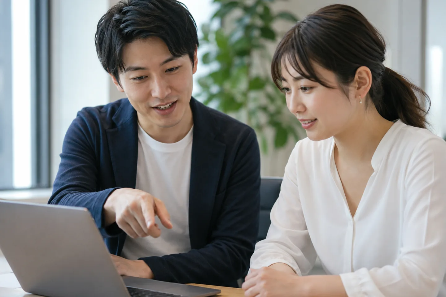 講師が受講者のPC画面を見ながら個別に指導している様子